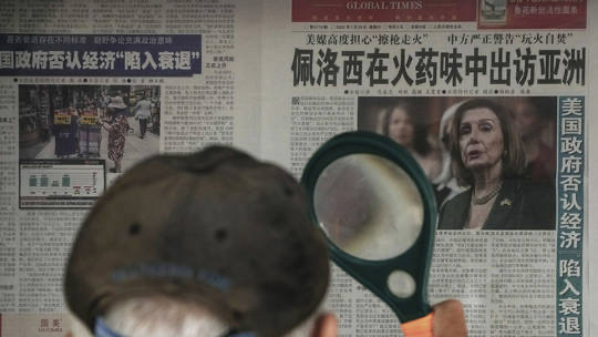 Reading the fine print at a news stand in Beijing. -Andy Wong:AP
