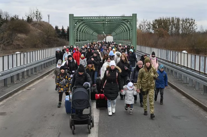 Ukrainian refugees walk into Poland and safety (count the men)  -Daniel Leal:AFP, GETTY