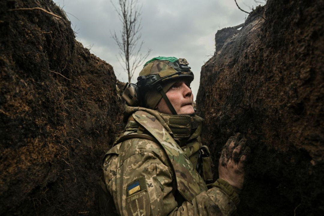 Ukrainian serviceman takes cover in a trench during shelling near the embattled city of Bakhmut, March 8, 2023 -Aris Messinis:AFP